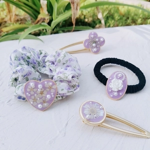 Detailed set of purple floral hair accessories with resin hearts and dried flowers
