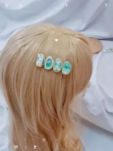 Détail d'une pince à cheveux bleue avec motif lapin blanc, tulipe et ours sur perruque