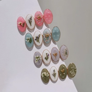 Vue détaillée de barrettes en résine faites main avec de vraies fleurs séchées et bords dorés