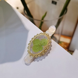 Handmade hair clip with real pressed four-leaf clover and gold foil in resin frame