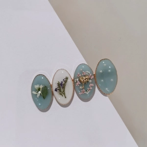 Barrette élégante avec fleurs séchées perles et cœurs dorés dans des blocs de résine