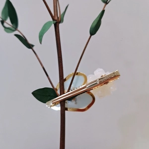 Detail of blue heart hair clip with white flower on a branch, Korean style accessory