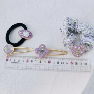 Macro detail of purple floral resin hair accessories set including scrunchies and clips