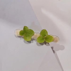 Handmade green hydrangea resin hair clip with natural dried flowers on white background