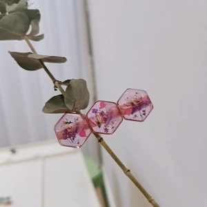 Details von echten rosa und lila Trockenblumen in sechseckigen Haarspangen aus Harz