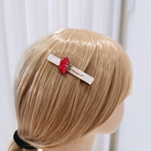 Elegant floral hairpin with red rose on white marble base worn on blonde hair