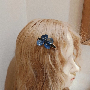 Handmade dark botanical resin hair clip with blue dried flowers and gold foil details