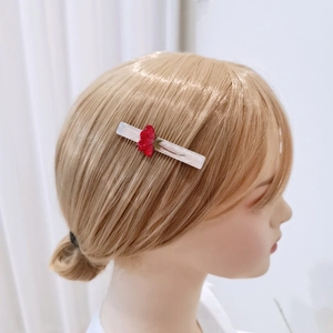 Detailed view of a handmade resin hair clip with an embedded red rose floral specimen