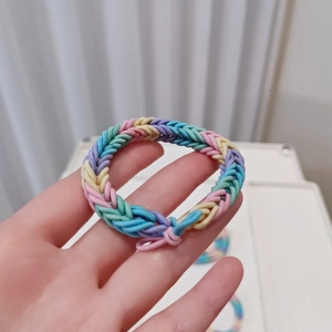Macro shot of colorful woven elastic hair ties with rainbow macaron spiral texture