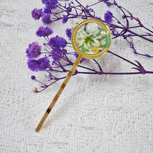 Détail macro d'une barrette faite main avec de vraies fleurs séchées et résine