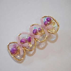 Barrette en résine avec fleurs séchées violettes et nœud rose dans un cadre doré