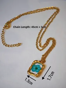 Dettaglio della collana dorata con ciondolo fiore blu pressato, misure 1,3 cm x 1,7 cm