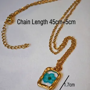 Collana in acciaio inossidabile dorato con ciondolo rettangolare vintage e fiore blu essiccato