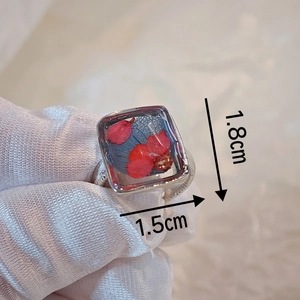 Detailed macro view of handmade dried flower resin ring surface measuring 1.8cm by 1.5cm