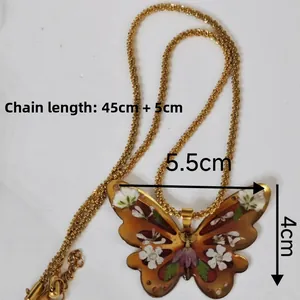 Détail du collier papillon fait main avec fleurs séchées et chaîne de 45cm de longueur