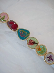Detail of handmade bracelet with real dried flowers in gold metal frames on lace