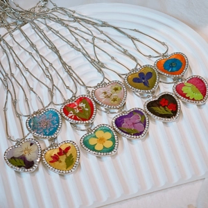 Detailed macro view of heart-shaped dry flower pendants with rhinestone borders