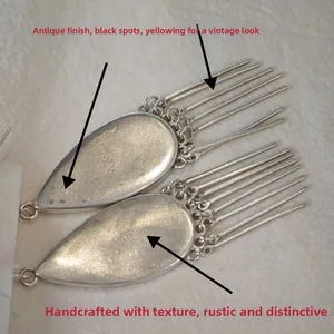 Detailed close-up of antique silver earrings with handmade vintage textured finish