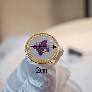 Detail view of handmade resin flower ring with purple petals and 2cm gold twisted frame