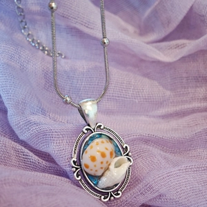 Handmade vintage seashell pendant necklace with stainless steel chain on purple tulle