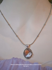 Detail of vintage handmade shell and conch pendant necklace on silver beaded snake chain