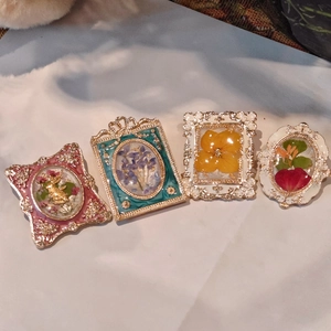 French vintage style enamel brooches featuring preserved real flowers and gold embossing