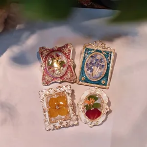 Vintage French floral enamel brooch set featuring colorful resin botanicals and gold frames