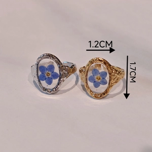 Handmade stainless steel rings with blue dried flowers in gold and silver oval frames