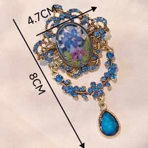 Vintage gold brooch with dried flowers, blue rhinestones and teardrop gemstone pendant