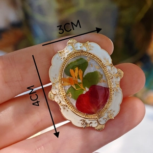 Detail macro of vintage oval resin brooch with real flowers and 4cm x 3cm size