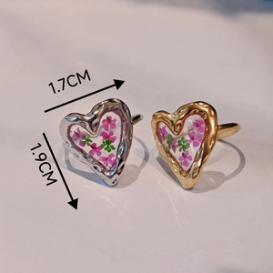 Macro shot of gold and silver heart rings with pink dried flowers and 1.7x1.9cm dimensions