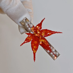 Pince à cheveux feuille d'érable en résine rouge avec paillettes dorées et perles blanches