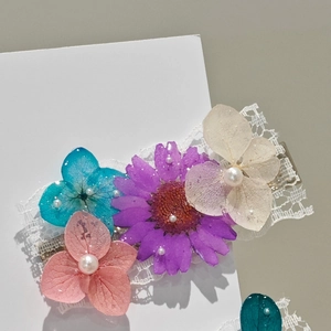 Detail of handmade lace hair clip with pressed dried flowers and pearl accents