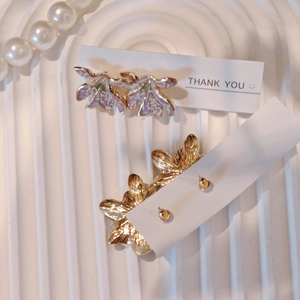 Detail view of vintage flower earrings with purple resin on a pearl background