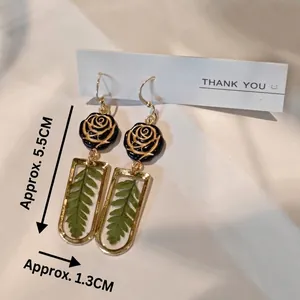 Handmade pressed leaf resin earrings with black rose design and 5.5cm length drop