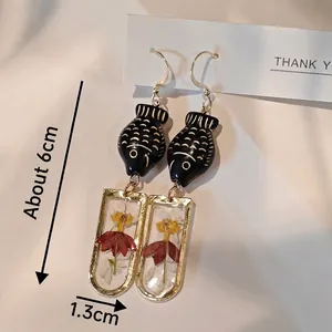 Handmade teardrop earrings with real red yellow dried flowers and black fish charm
