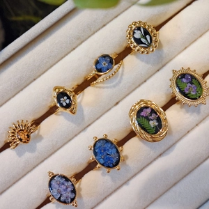 Collection of handmade gold stainless steel rings with real pressed flowers and botanical specimens