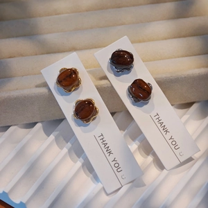 Handmade creative coffee bean earrings in gold and silver settings on a display card