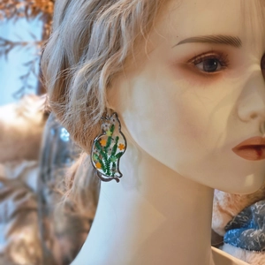 Macro shot of cat earring with resin dried flowers worn on a mannequin head