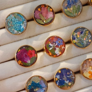 Handmade dried flower resin rings with gold-plated stainless steel bands in varied colors