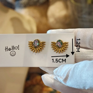 Macro shot of handmade gold sunflower earrings with pink dried flowers and dimensions 1.5cm