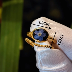 Detail of 1.7cm oval blue dried flower resin ring and gold beaded band set