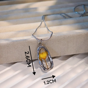 Detail shot of yellow dried flower resin pendant with 2.6cm by 1.2cm size markings