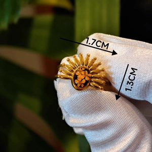 Macro detail of vintage gold sunflower ring with real dried flowers on white background