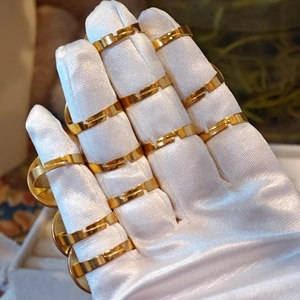 Close-up of bulk adjustable gold ring bases for DIY flower jewelry making on white gloves