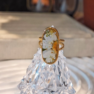 Handgefertigter ovaler Harzring mit weißen Trockenblumen und goldener Kordelband