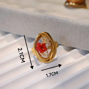 Detail view of the 2.1x1.7cm oval handmade ring with red and white dried flowers
