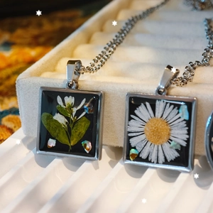Handmade black square resin pendant necklace featuring real dried flowers and stainless steel
