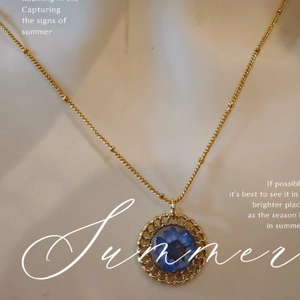 Handmade gold pendant necklace with a blue dried flower in a round woven frame