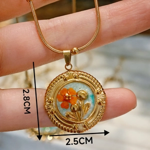 Detailansicht des 2,8 cm Vintage-Anhängers mit oranger Blume und goldener Schlangenkette